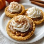 “pumpkin pie cookie topped with whipped cream and sprinkled with cinnamon on a white plate — cozy fall dessert.”
