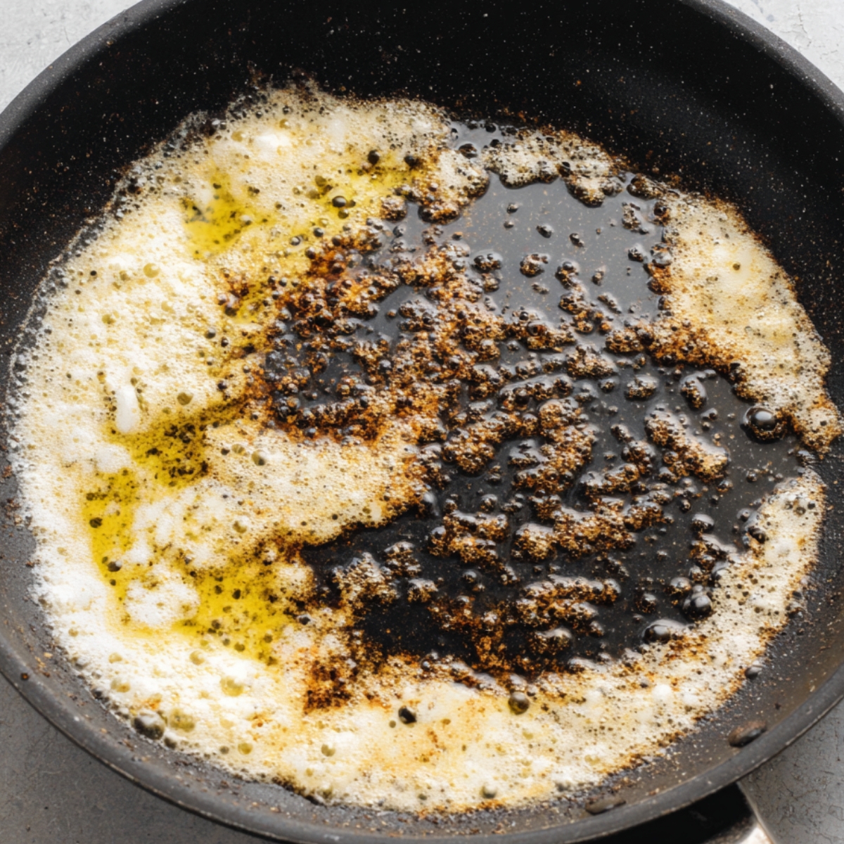 Butter and oil sizzling in a skillet, with seasoning bubbling at the edges