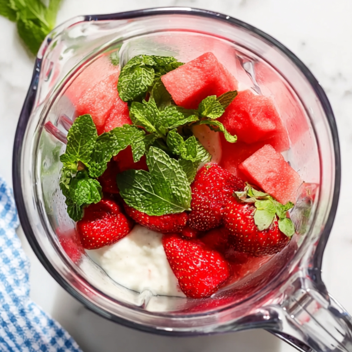Watermelon, strawberries, yogurt, and mint in a blender.