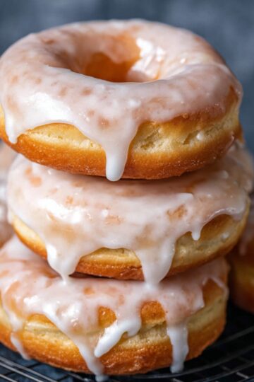 Stack of glazed Amish donuts with icing dripping down the sides.