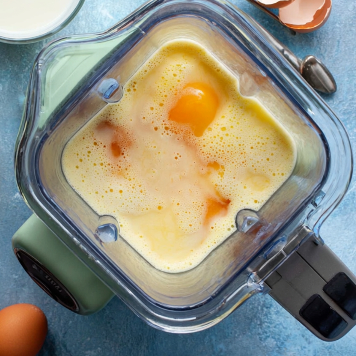 Egg custard mixture being blended in a blender.