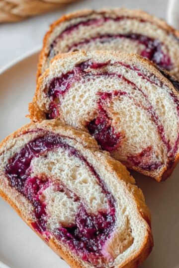 Slices of blueberry cream cheese babka with a soft, airy texture and a swirl of berry filling.