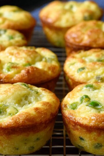 The image shows Fluffy Cottage Cheese Egg Muffins with visible green onions, cooling on a wire rack.