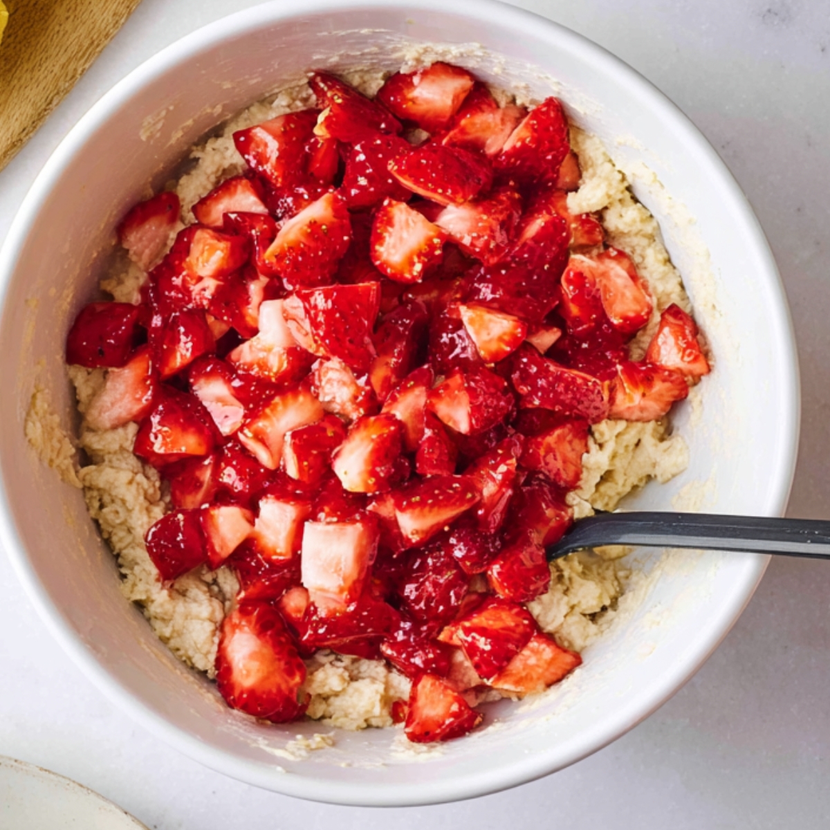 Fresh strawberries mixed into the dough, ready to be folded into the batter.