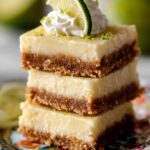 Stacked Key Lime Pie Bars with whipped cream.