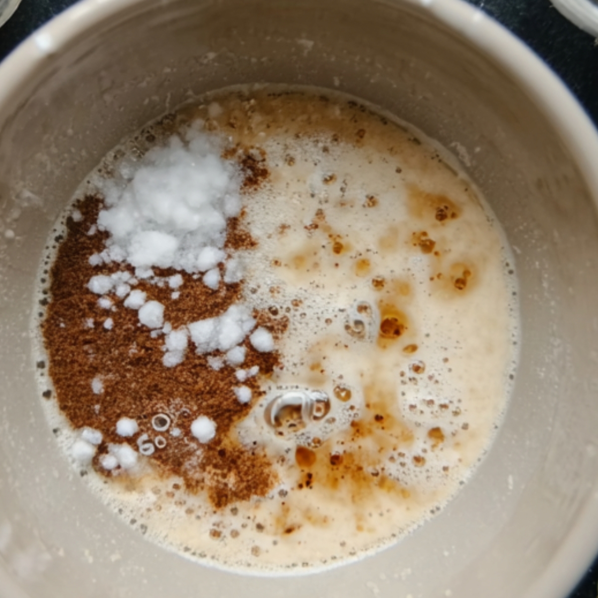 The image shows a mixture of wet ingredients, including what looks like yeast, salt, and possibly some spices, in a container. Would you like to know the next steps for a recipe?