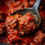 Chunks of Nigerian beef stew simmering in rich tomato stew