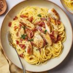 Chicken carbonara with spaghetti, crispy bacon, and Parmesan.